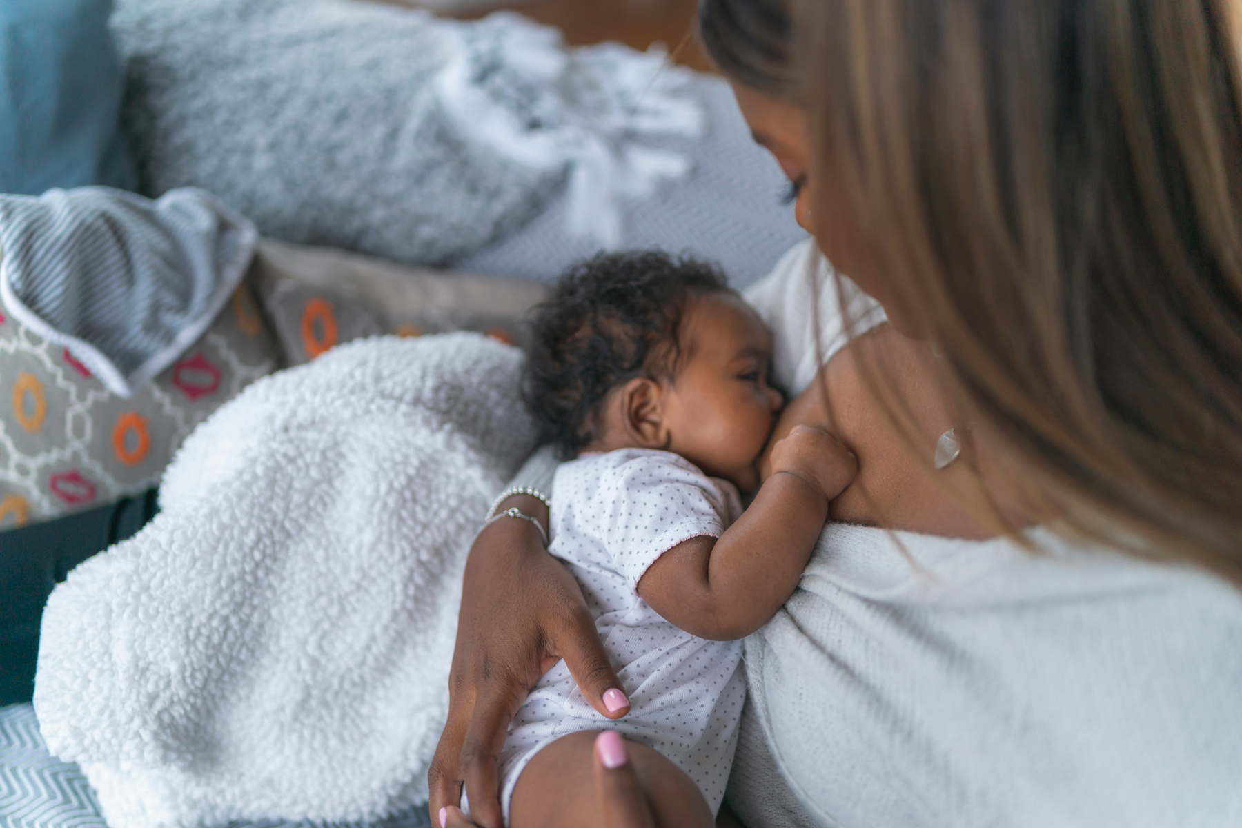 Mother breastfeeding newborn baby girl